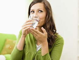A woman drinking a glass of water.