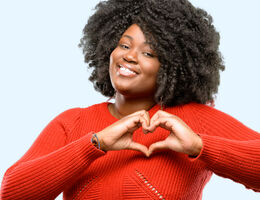 A woman forms a heart shape with her hands.