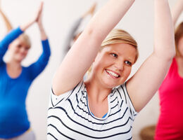 Smiling women exercise together.