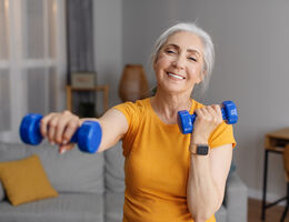 An older woman working out with hand weights.